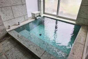 a swimming pool in a room with a window at i.1012 IZU in Ito