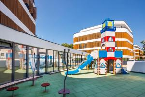a playground in front of a building with a slide at Baltic Waves Resort by PI Apartments - Official Operator in Międzyzdroje