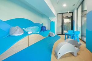 a room with a bed with pillows and a dolphin on it at Baltic Waves Resort by PI Apartments - Official Operator in Międzyzdroje