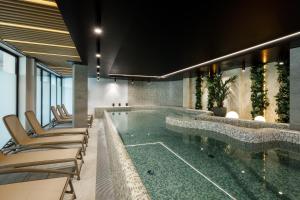 a swimming pool with lounge chairs and a spa at Baltic Waves Resort by PI Apartments - Official Operator in Międzyzdroje