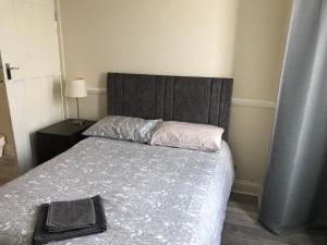 a bedroom with a bed with a gray headboard and a bed sidx sidx sidx at Ac Lounge 36 Room A in Rochford