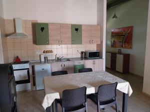 une cuisine avec une table et des chaises et une cuisine avec un évier dans l'établissement Tomaj Vendégház, à Tomajmonostora 32 autres photos