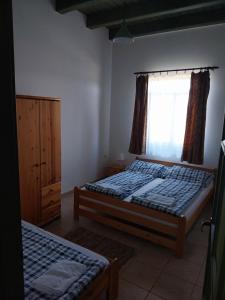 une chambre avec deux lits et une fenêtre dans l'établissement Tomaj Vendégház, à Tomajmonostora