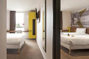 Łóżko lub łóżka w pokoju w obiekcie Brit Hotel Toulouse Colomiers – L’Esplanade