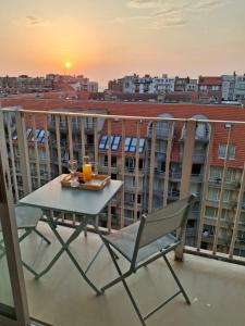 een tafel en stoel op een balkon met uitzicht op de stad bij Studio Seasant in Nieuwpoort