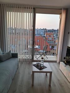 een woonkamer met een bank en een tafel en een groot raam bij Studio Seasant in Nieuwpoort