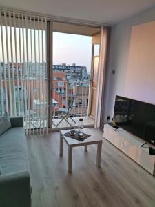 een woonkamer met een bank en een groot raam bij Studio Seasant in Nieuwpoort