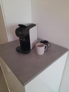 een koffiezetapparaat en twee kopjes op een aanrecht bij Studio Seasant in Nieuwpoort +6 foto's