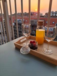 een dienblad met wijnglazen en een drankje op een balkon bij Studio Seasant in Nieuwpoort