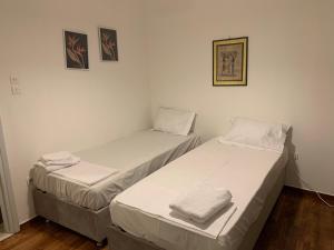 two beds in a room with white walls at ALEX house in Athens