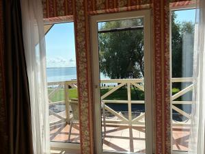 a door to a balcony with a view of the ocean at Kurenas in Juodkrantė