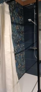 a bathroom with blue walls and a shower curtain at Les roses d'Olga in Aubechies