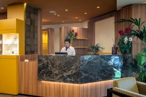 a man standing behind a counter in a lobby at Hotel Argentina in Grado