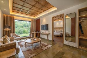 un soggiorno con divano, tavolo e letto di Kananwas Resort, Kumbhalgarh a Kumbhalgarh