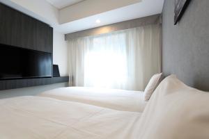 Postel nebo postele na pokoji v ubytování KOKO HOTEL Ginza-1chome