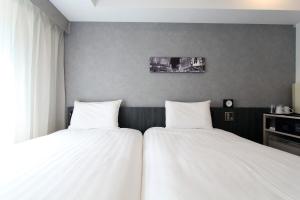 Postel nebo postele na pokoji v ubytování KOKO HOTEL Ginza-1chome