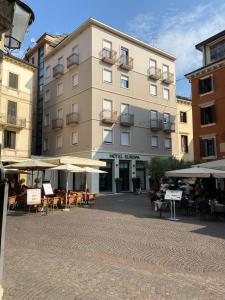 a building with tables and umbrellas in front of it at Hotel Europa in Verona
