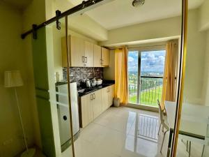 a kitchen with green walls and a large window at La Cassandra at SMDC Wind Residences Tower 2 - Tagaytay City in Tagaytay