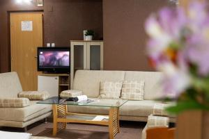a living room with a couch and a coffee table at Hotel Brod - Free Parking in Sofia