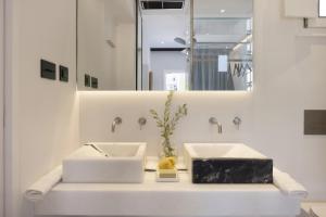 a bathroom with two sinks and a mirror at Modern studio in the heart of Old Port in Spetses in Spetses