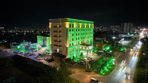 a building with green lights in a city at night at Garden Hotel & SPA in Bishkek
