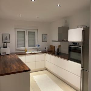 a kitchen with white cabinets and a stainless steel refrigerator at Villa Elezovic in Čapljina