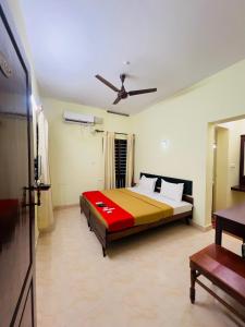 a bedroom with a bed and a ceiling fan at Hotel Sunday - Townhouse Club Airport Trivandrum in Trivandrum