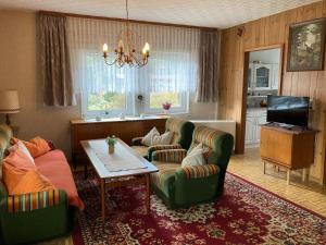 a living room with two green chairs and a table at Ferienhaus Klein in Winsen