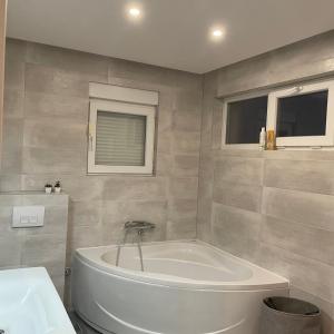 a bathroom with a white tub and a sink at Villa Elezovic in Čapljina +18 photos