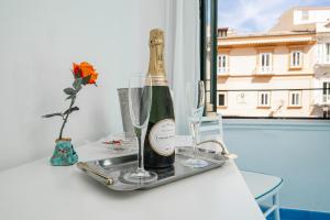 Una botella de champán y dos copas en una bandeja. en Albergo S. Andrea, en Amalfi
