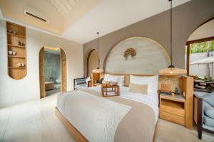 スミニャックにあるAstera Villa Seminyak by Ini Vie Hospitalityの大きなベッドとバスルームのある寝室