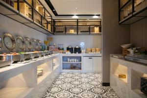 una cucina con bancone, lavandini e pavimento piastrellato di Eharm Hotel Jingzhou Olympic Sports Center a Jingzhou