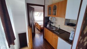 a small kitchen with a sink and a bedroom at Pokoje Gościnne Barka - 300m do RESTAURACJI - 900m do JEZIORA i VELO CZORSZTYN in Kluszkowce +69 photos