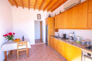 Una cocina con gabinetes de madera y una mesa en ella. en Villa Meloi patmos, en Patmos 9 fotos más