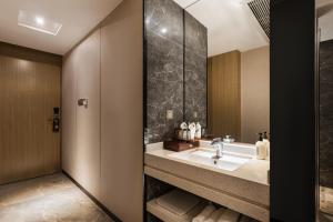 广州Paco Hotel Tianpingjia Metro Guangzhou - Free Shuttle Bus For Canton Fair的带水槽和镜子的浴室