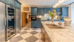 cocina con armarios azules y suelo a cuadros en Kentchurch Park, en Kentchurch 43 fotos más