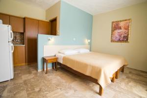 sypialnia z łóżkiem i lodówką w obiekcie Acropolis Hotel w mieście Masouri