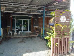 a porch of a house with a table and a bench at มังกรเลโฮสเทล Mangkonlay Hostel in Ban Khlong Pak
