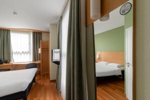 a hotel room with two beds and a mirror at Ibis Kaunas Centre in Kaunas +134 photos