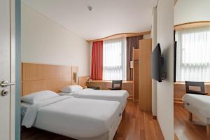 a hotel room with two beds and a tv at Ibis Kaunas Centre in Kaunas +37 photos