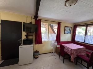 a living room with a table and a kitchen with a table and a tablektop at 2 hálószobás vendégház in Balatonboglár