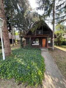 a small house with a porch and a tree at 2 hálószobás vendégház in Balatonboglár