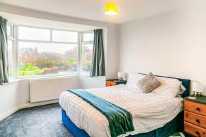 a bedroom with a bed and a window at The Lookout, Seaside Getaway in Cleveleys