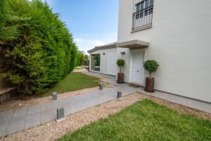 ein weißes Haus mit zwei Topfpflanzen in einem Hof in der Unterkunft Villa Dudu in Adeje