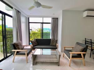 ein Wohnzimmer mit einer Couch und zwei Sesseln in der Unterkunft 360 Degree Kamala Seaview Villa in Kamala Beach
