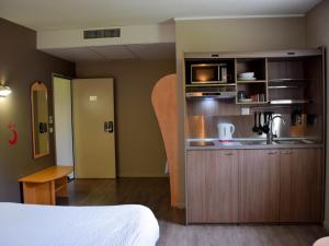 a hotel room with a kitchen and a bed at Hotel Aurena in Aurillac