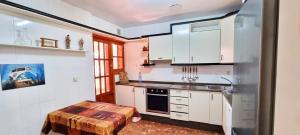 a kitchen with white cabinets and a table in it at Casa con Piscina Privada - By Aloha Palma in Calabardina