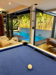 a pool table in a room with a swimming pool at 174曼谷素坤逸私人泳池五卧花园别墅 in Amphoe Phra Khanong