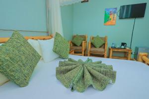 a large white bed with pillows on top of it at Shine Country Resort Hotel in Naziba