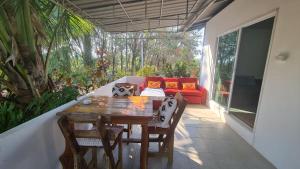 un patio con un tavolo di legno e un divano rosso di Koh Mak Garden View a Ko Mak